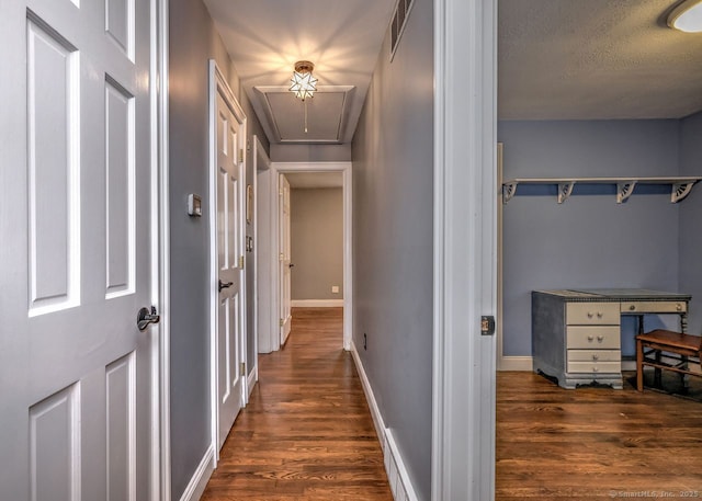 hall featuring dark hardwood / wood-style floors and a textured ceiling