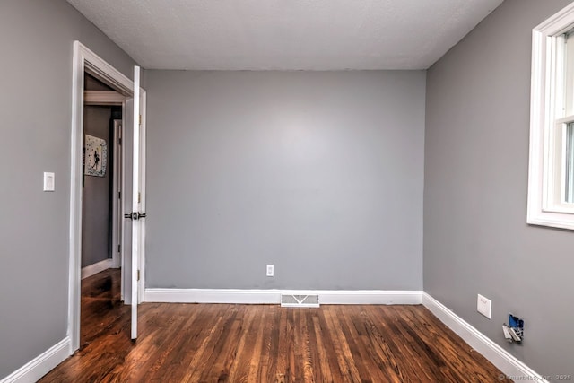 unfurnished bedroom featuring dark wood-type flooring and a textured ceiling