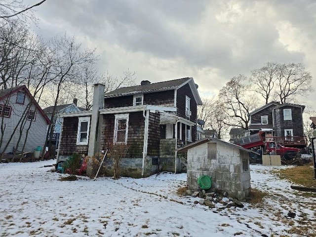 view of snow covered back of property