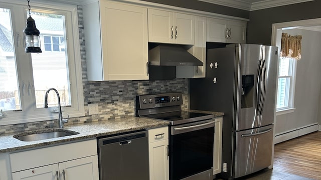 kitchen featuring sink, wall chimney range hood, baseboard heating, stainless steel appliances, and white cabinets