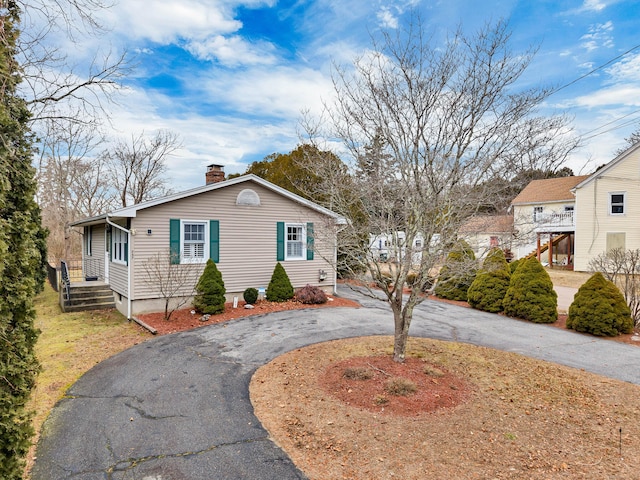 view of front of property with driveway and a chimney