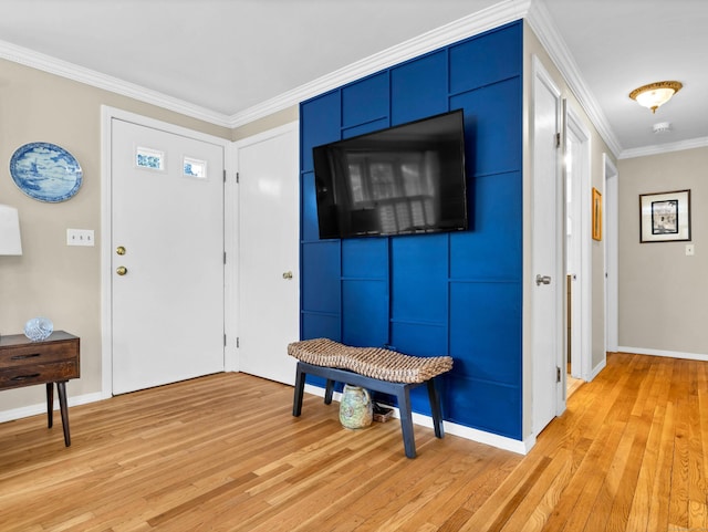 foyer featuring light wood-style flooring, baseboards, and ornamental molding