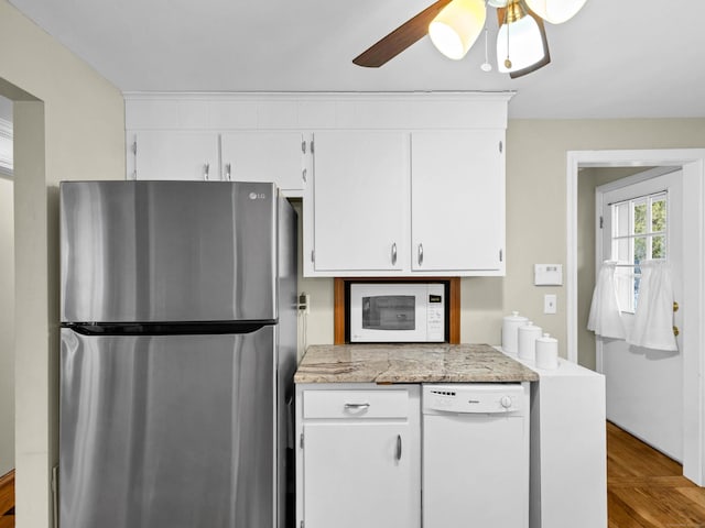 kitchen featuring light stone counters, white appliances, white cabinets, and a ceiling fan