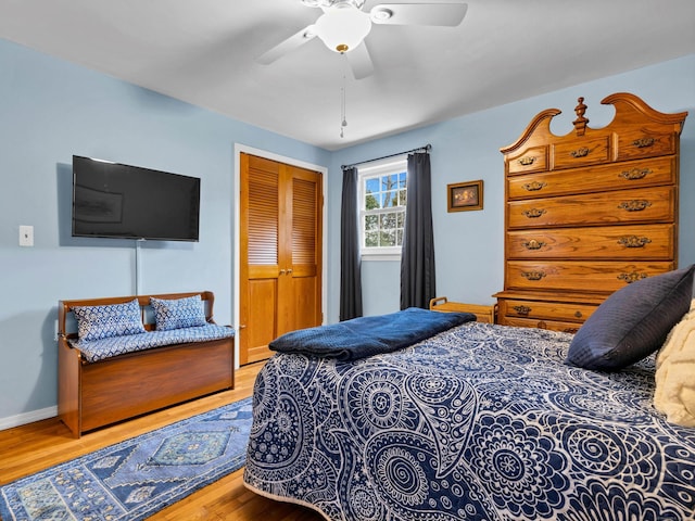 bedroom with a ceiling fan, wood finished floors, a closet, and baseboards