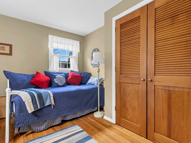 bedroom with a closet, baseboards, and wood finished floors