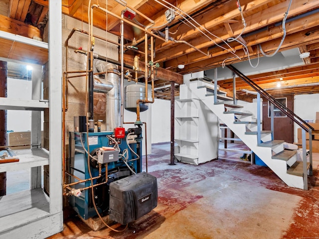 unfinished basement with stairway and a heating unit