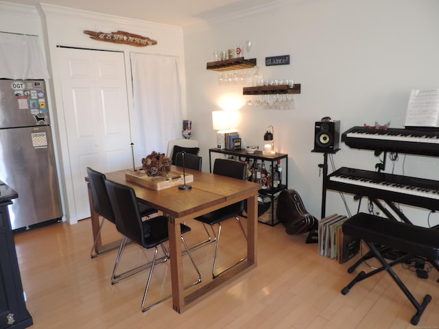 dining space with ornamental molding and light wood-type flooring