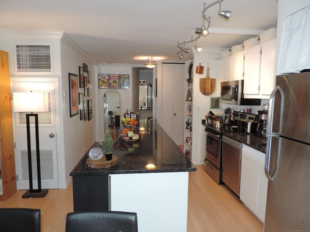 kitchen featuring crown molding, stainless steel appliances, light hardwood / wood-style floors, and white cabinets