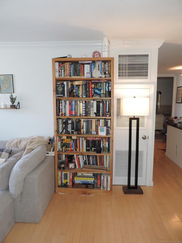 living area featuring ornamental molding and light wood-type flooring