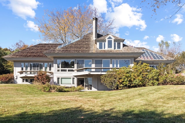 rear view of house with a yard and a chimney