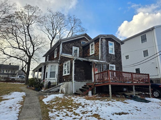 snow covered house featuring a deck