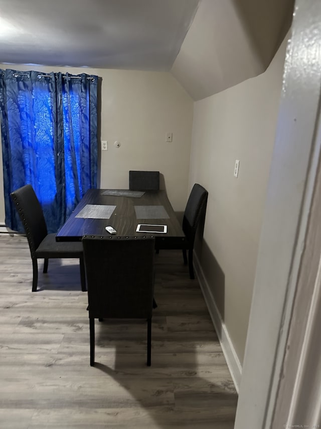 dining space featuring lofted ceiling and hardwood / wood-style flooring