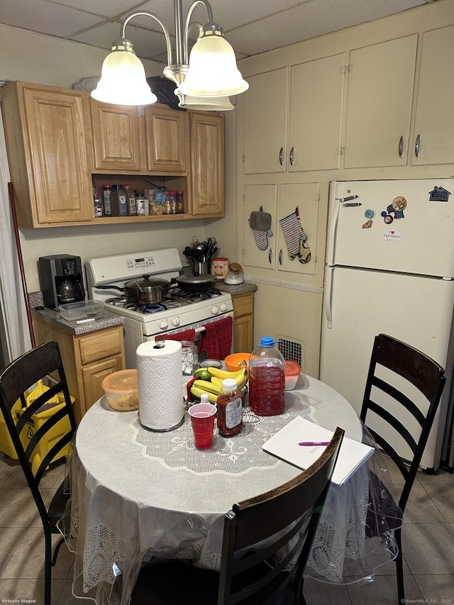 kitchen featuring pendant lighting, tile patterned flooring, white appliances, and a drop ceiling