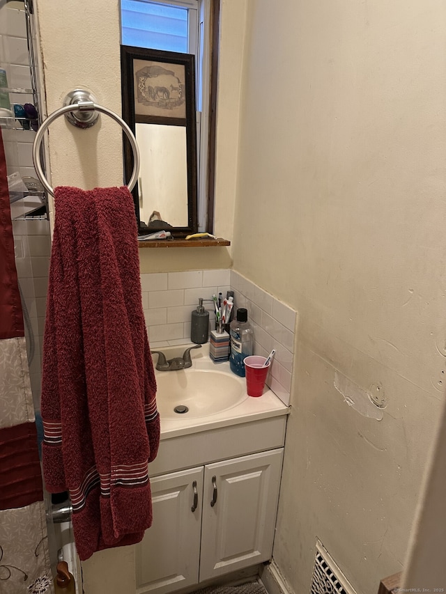 bathroom featuring vanity and decorative backsplash