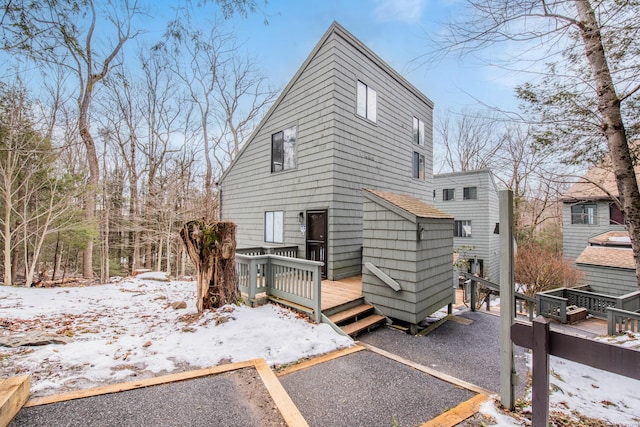 snow covered property featuring uncovered parking and a wooden deck