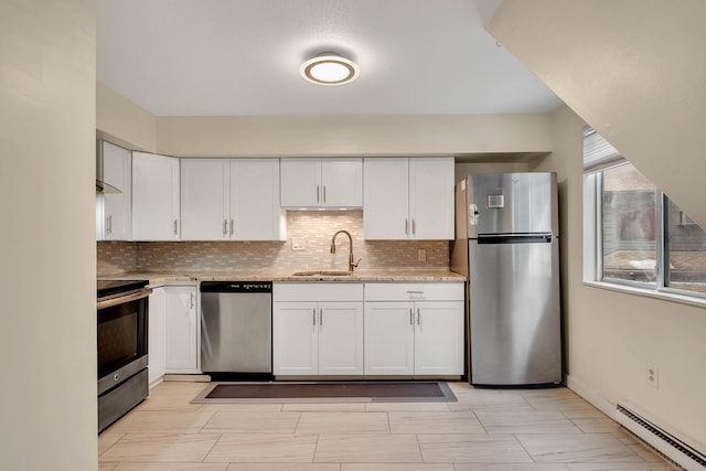 kitchen with stainless steel appliances, a baseboard heating unit, a sink, and tasteful backsplash