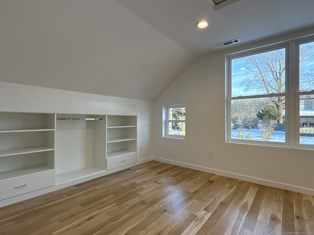 bonus room featuring lofted ceiling, built in features, and light wood-type flooring