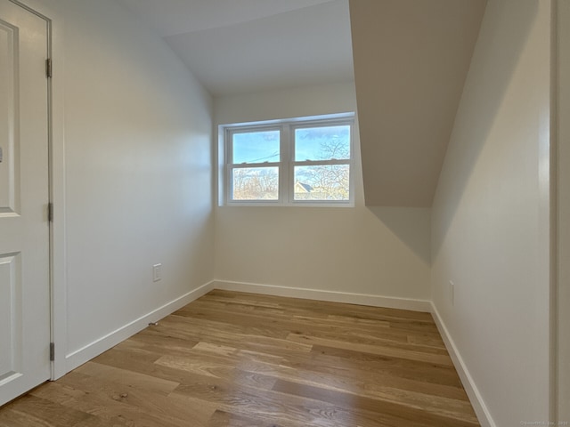 additional living space with lofted ceiling and light hardwood / wood-style flooring