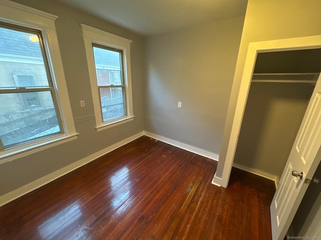 unfurnished bedroom featuring dark hardwood / wood-style floors and a closet