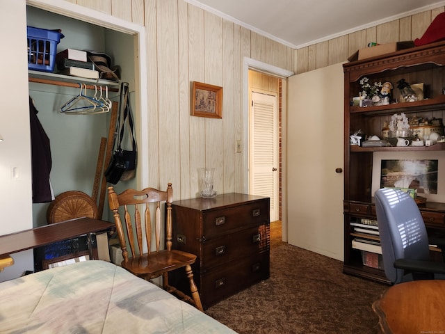 bedroom featuring wooden walls, ornamental molding, and dark colored carpet