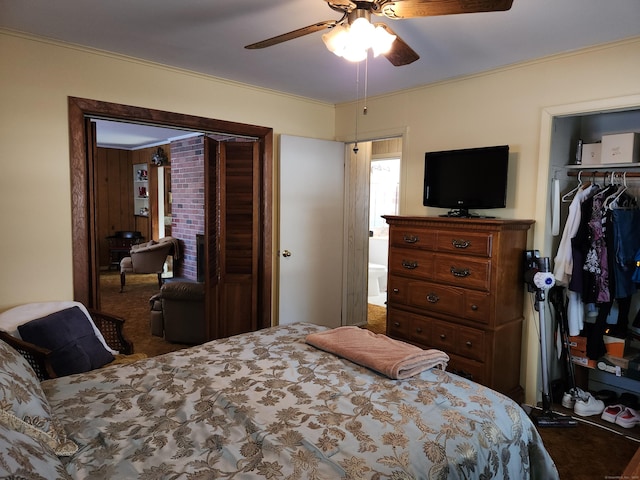 bedroom featuring ceiling fan, dark colored carpet, ornamental molding, a spacious closet, and a closet