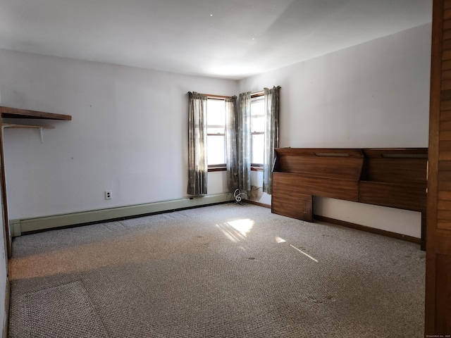 carpeted empty room with a baseboard heating unit