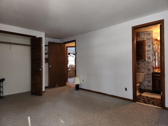 unfurnished bedroom featuring connected bathroom, carpet floors, and a closet