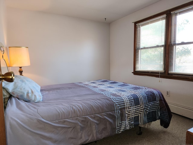 carpeted bedroom featuring a baseboard heating unit