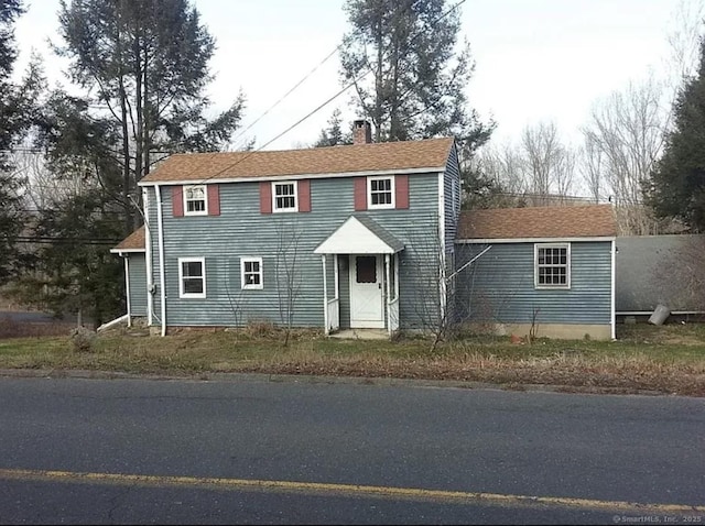 colonial-style house featuring a chimney