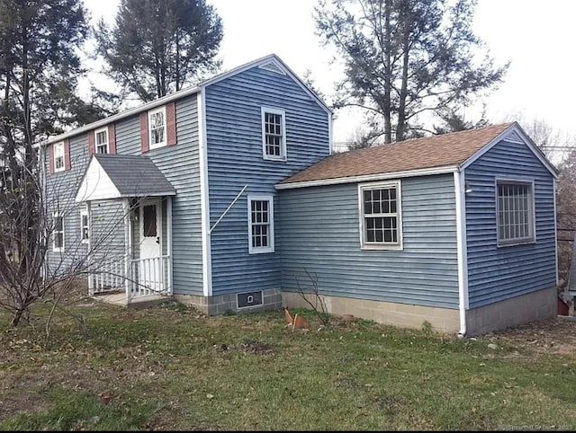 view of front of home featuring a front yard and a shingled roof