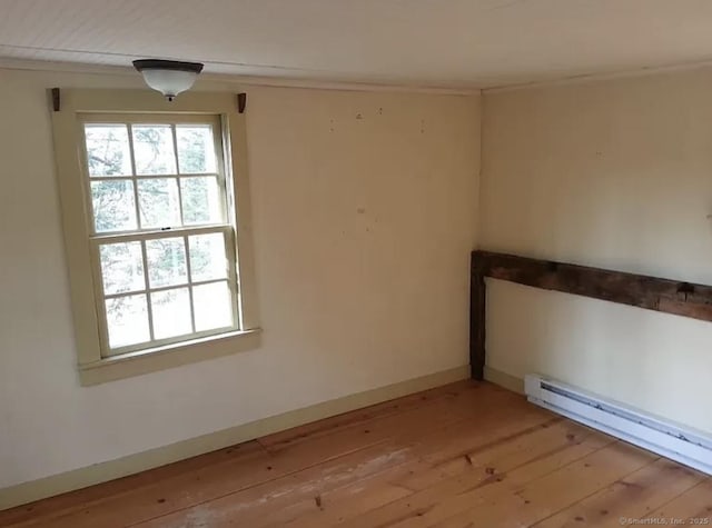 unfurnished room featuring light wood-style floors, a baseboard heating unit, baseboards, and ornamental molding