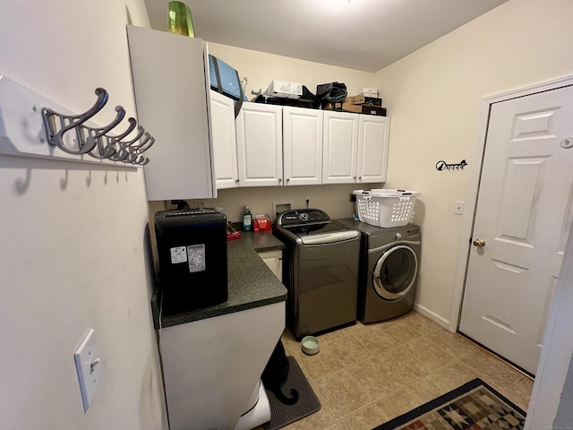 washroom featuring cabinets, washing machine and clothes dryer, and light tile patterned flooring