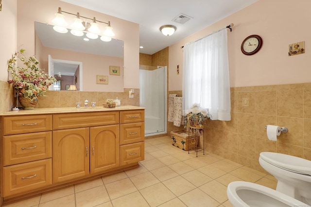 bathroom featuring tile walls, vanity, tile patterned flooring, and a bidet