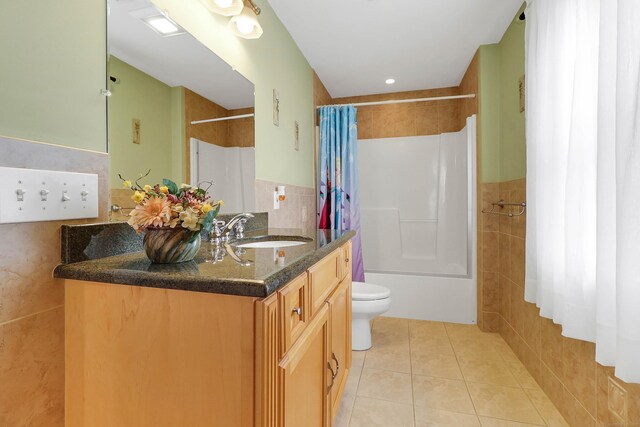 bathroom featuring tile patterned floors, toilet, tile walls, and vanity