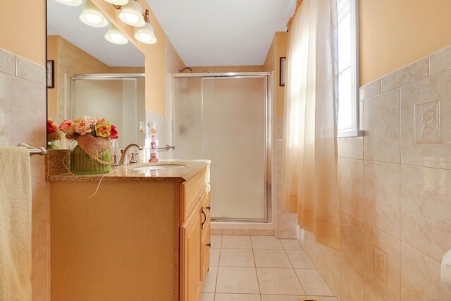 bathroom featuring tile patterned flooring, vanity, and a shower with shower door