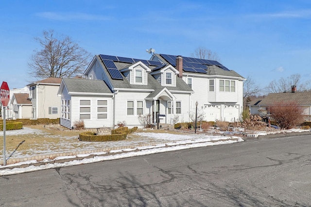 view of front of property featuring solar panels, a chimney, an attached garage, and a residential view