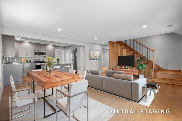 living room featuring sink and light hardwood / wood-style flooring