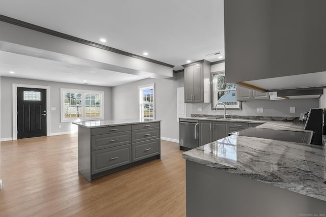 kitchen featuring sink, gray cabinetry, light wood-type flooring, stainless steel dishwasher, and a kitchen island