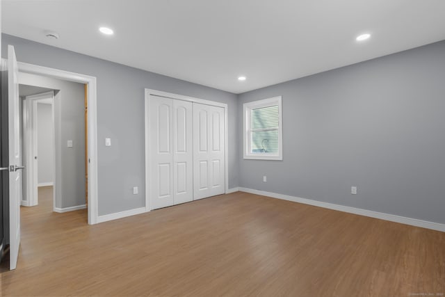 unfurnished bedroom featuring a closet and light wood-type flooring