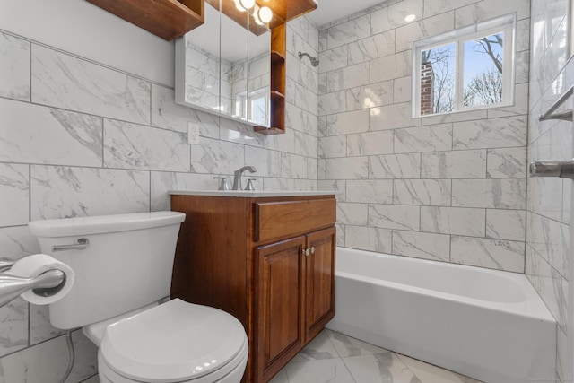 full bathroom featuring tiled shower / bath, vanity, toilet, and tile walls