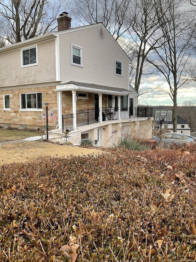 back of property featuring covered porch