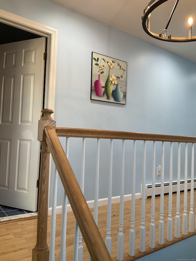 stairway with a baseboard radiator and wood-type flooring