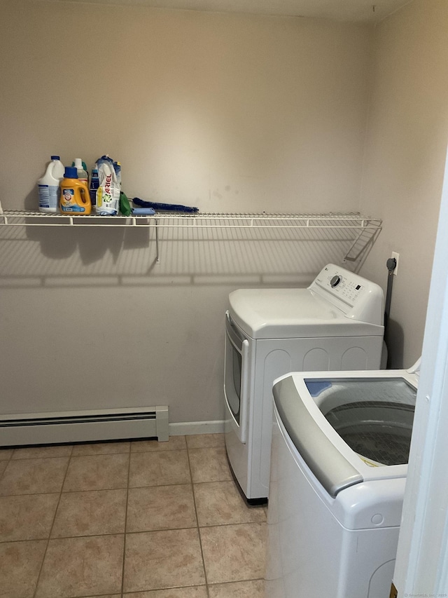 laundry area with washing machine and dryer, light tile patterned floors, and baseboard heating