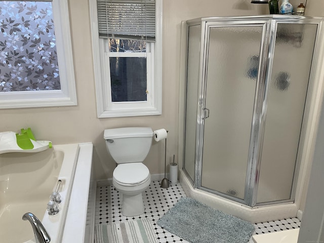 bathroom featuring toilet, plenty of natural light, tile patterned floors, and a shower with shower door