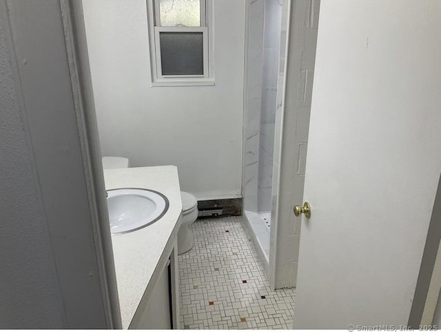 bathroom with tile patterned floors, vanity, toilet, and a shower