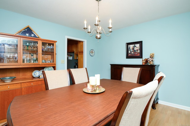 dining area featuring an inviting chandelier and light wood-type flooring