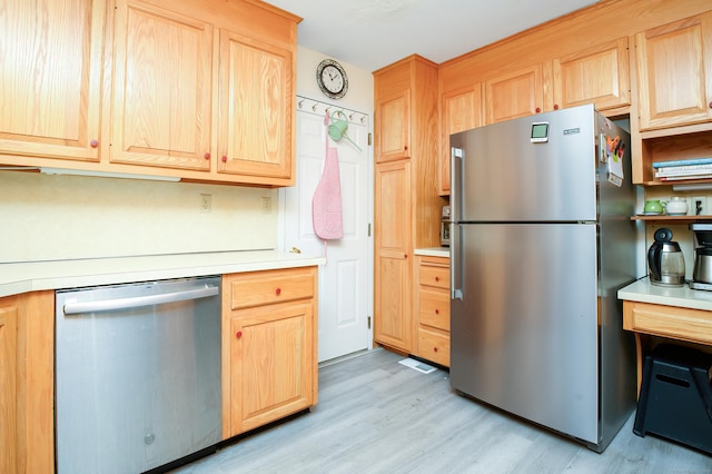 kitchen with appliances with stainless steel finishes, light brown cabinetry, and light hardwood / wood-style flooring