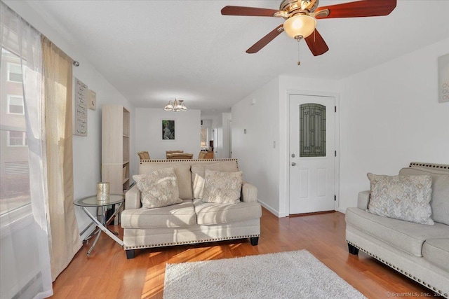 living room with wood-type flooring and ceiling fan