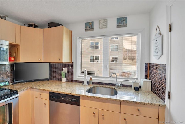 kitchen featuring sink, appliances with stainless steel finishes, light stone countertops, light brown cabinetry, and decorative backsplash