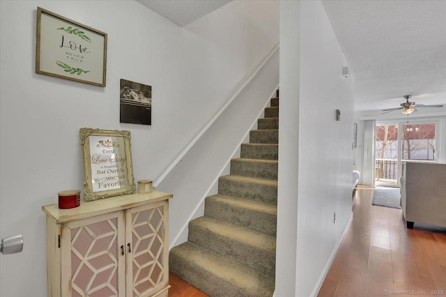 stairway featuring hardwood / wood-style floors, a textured ceiling, and ceiling fan